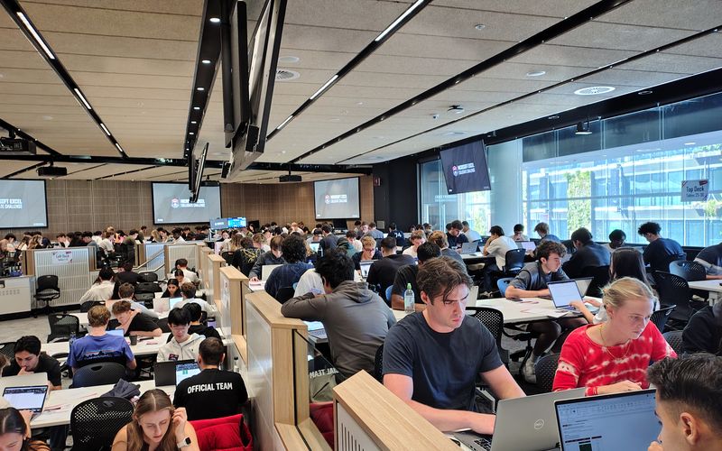 A lecture hall of students working on laptops during a MECC regional competition.